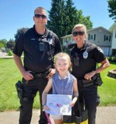 A police officer stands beside a girl